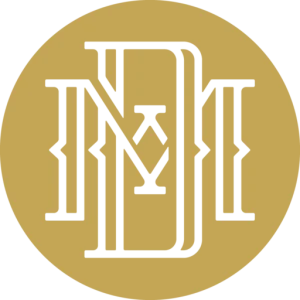 A circular gold seal with a black ornate monogram combining letters I, M, and M in a stylized medieval font.