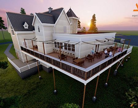 A modern white two-story house perched on stilts with a wraparound deck and outdoor seating, overlooking a grassy yard at sunset.