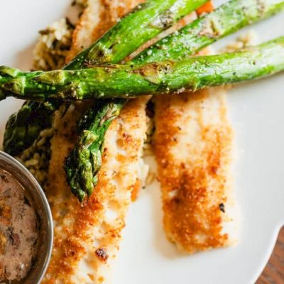 Cried? No. Salmon? No. It shows breaded white fish with crispy coating and grilled asparagus, plus a dipping sauce on the side.