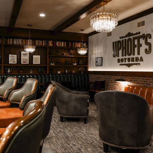 A coffee shop scene with warm lighting, orange chairs, and a few patrons seated at tables.