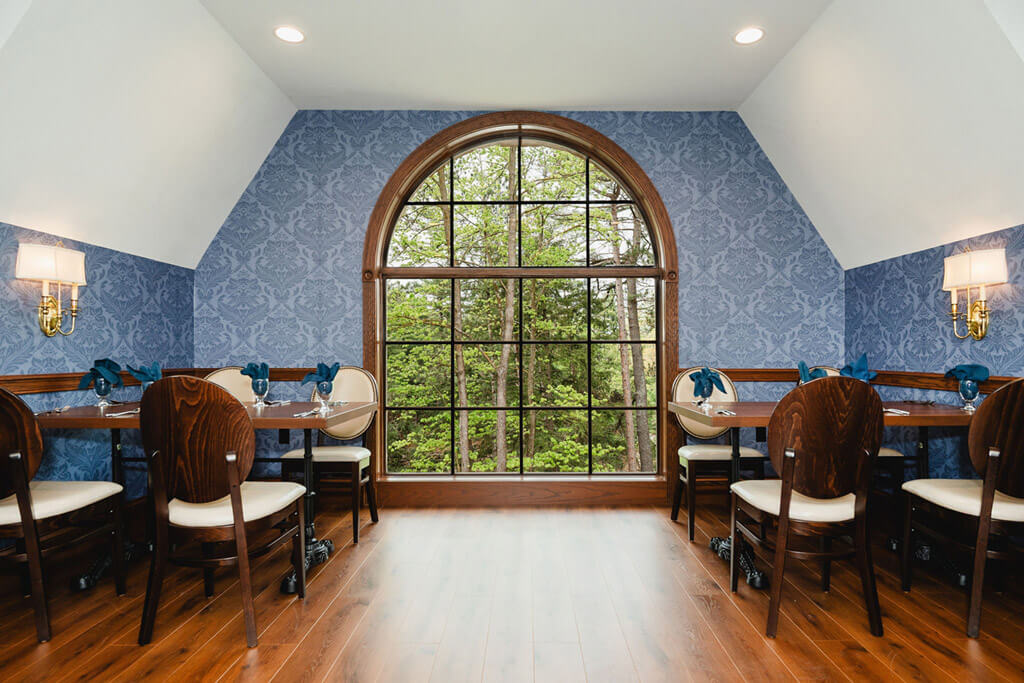 Arched window overlooking trees in the Raab Room