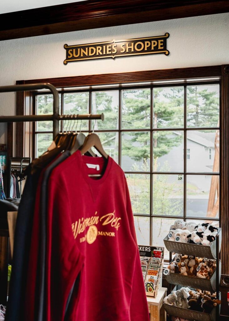 Sundries Shoppe sign over Dawn Manor branded crew necks and toy plushes