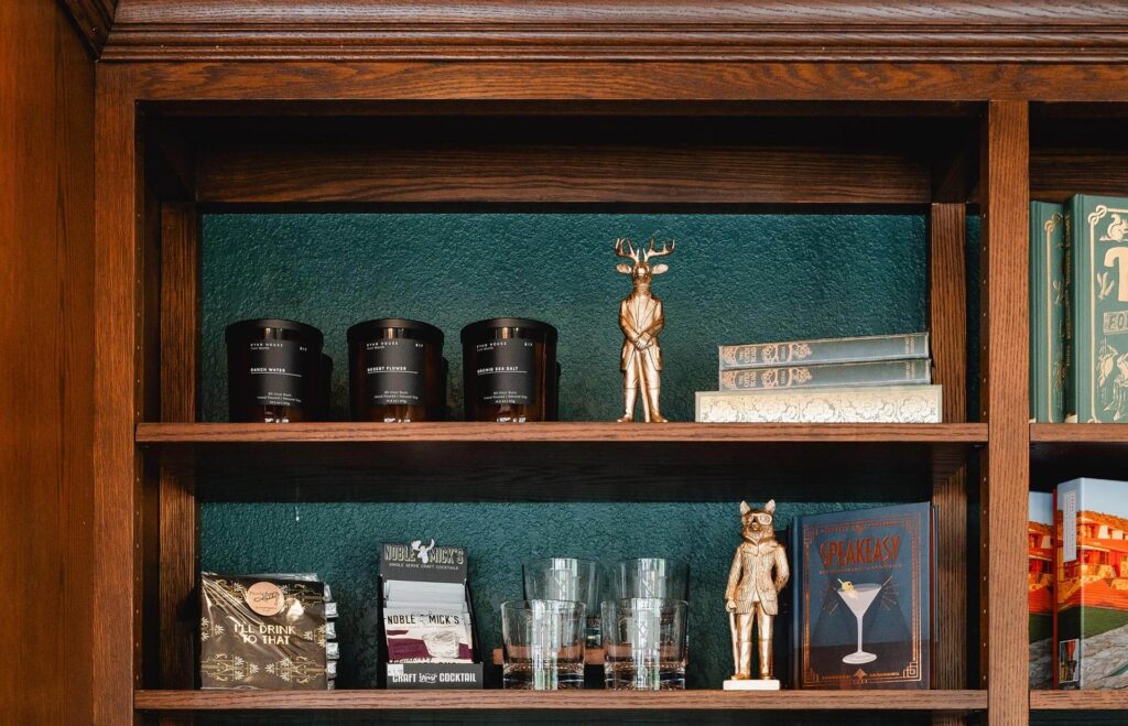 shelves with candles, glassware, and books at the Sundries Shoppe