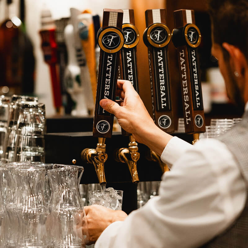 Bartender pulling Tattersall tap in Uphoff's Rotunda